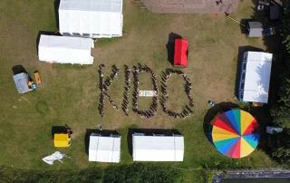 Luftbild mit Kindern und Betreuenden, die das Wort Kido bilden