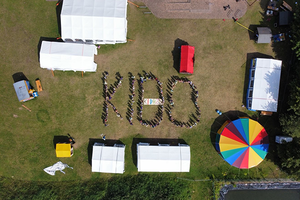 Luftbild mit Kindern und Betreuenden, die das Wort Kido bilden